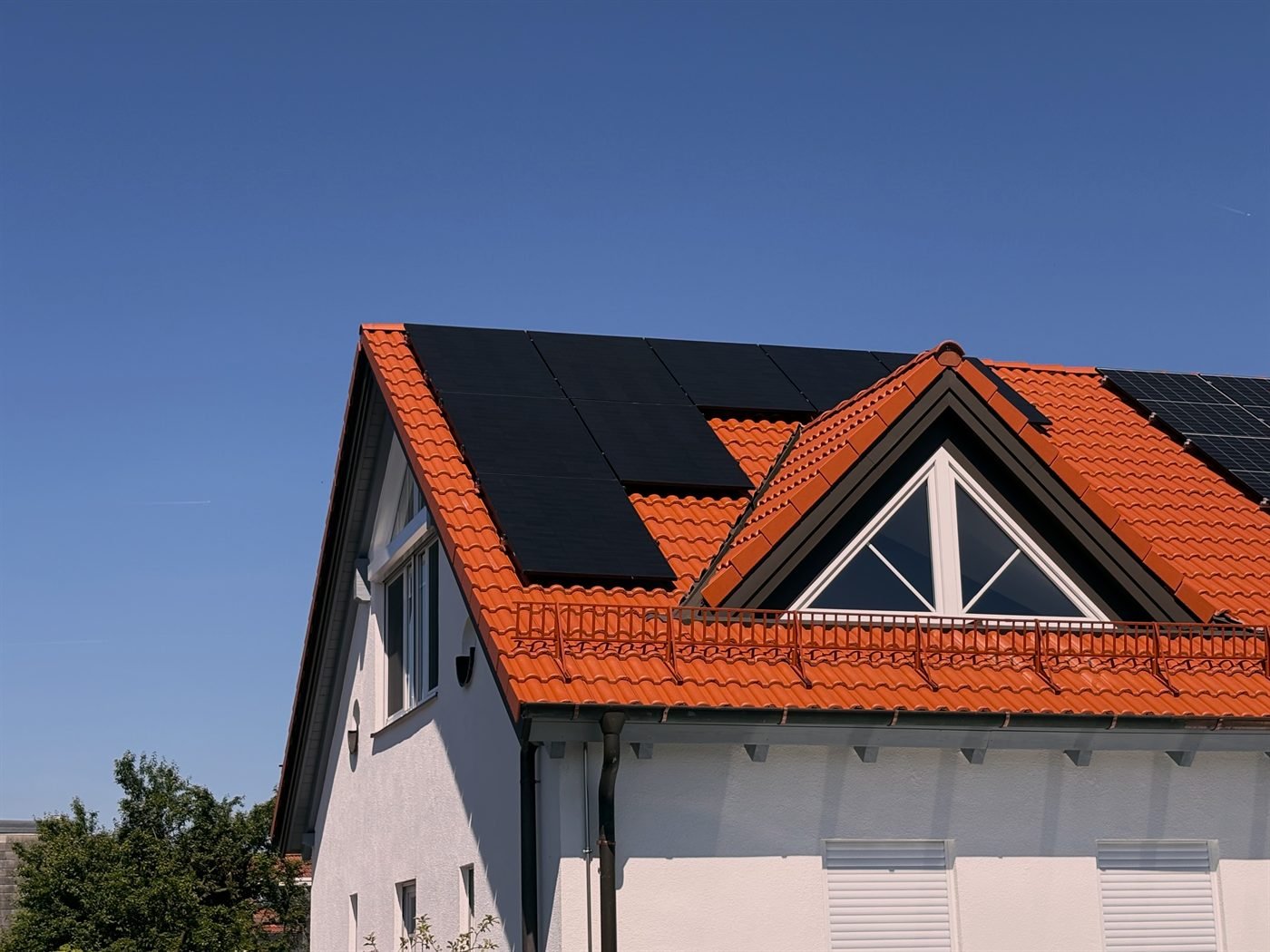 Photovoltaik-Anlage mit schwarzen Modulen auf einem Satteldach mit roten Ziegeln
