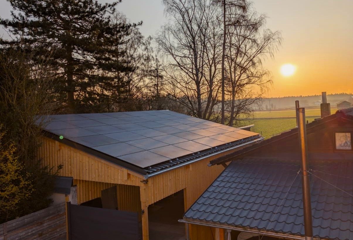 Solarmodule auf dem Dach eines Nebengebäudes im Licht der Abendsonne